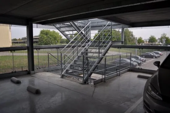 Gegalvaniseerde buitentrap met roostertreden in een open parkeergebouw