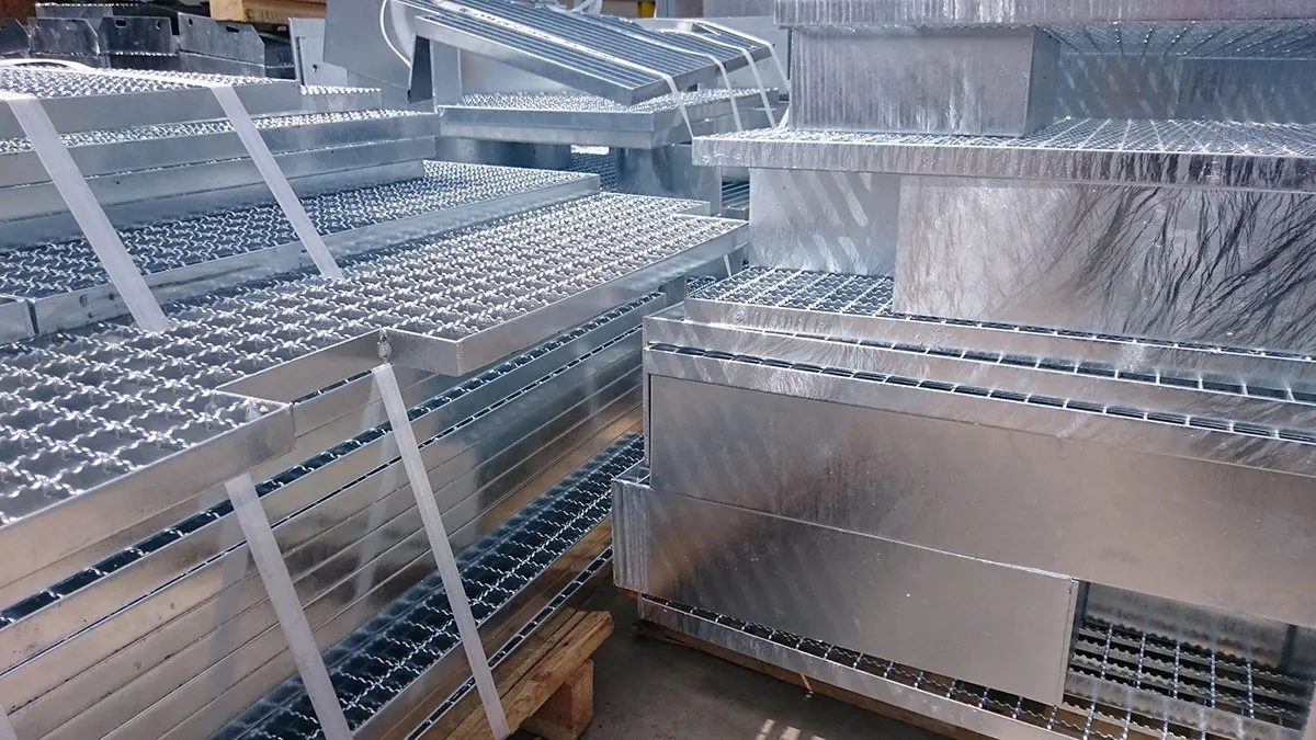 Stapels gegalvaniseerde traptreden en roosters met getande staven, klaar voor levering
