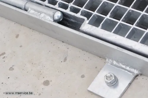 Close-up van scharnier aan roosterkader met gelaste bevestigingslip en bout